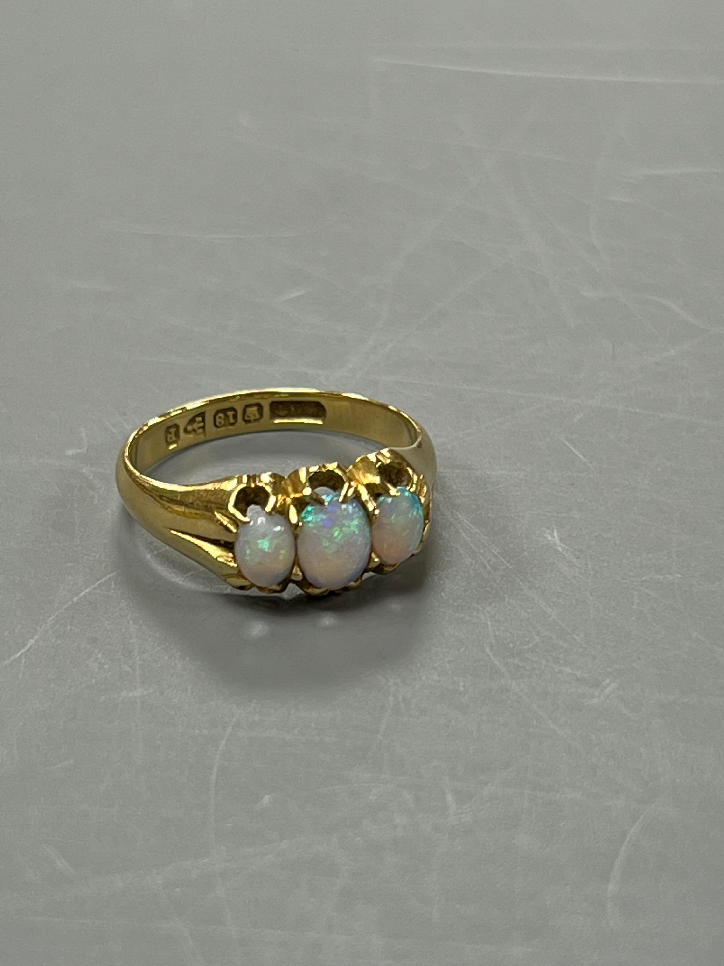 A late Victorian 18ct gold and claw set three stone white opal ring, size M, gross weight 4.1 grams.